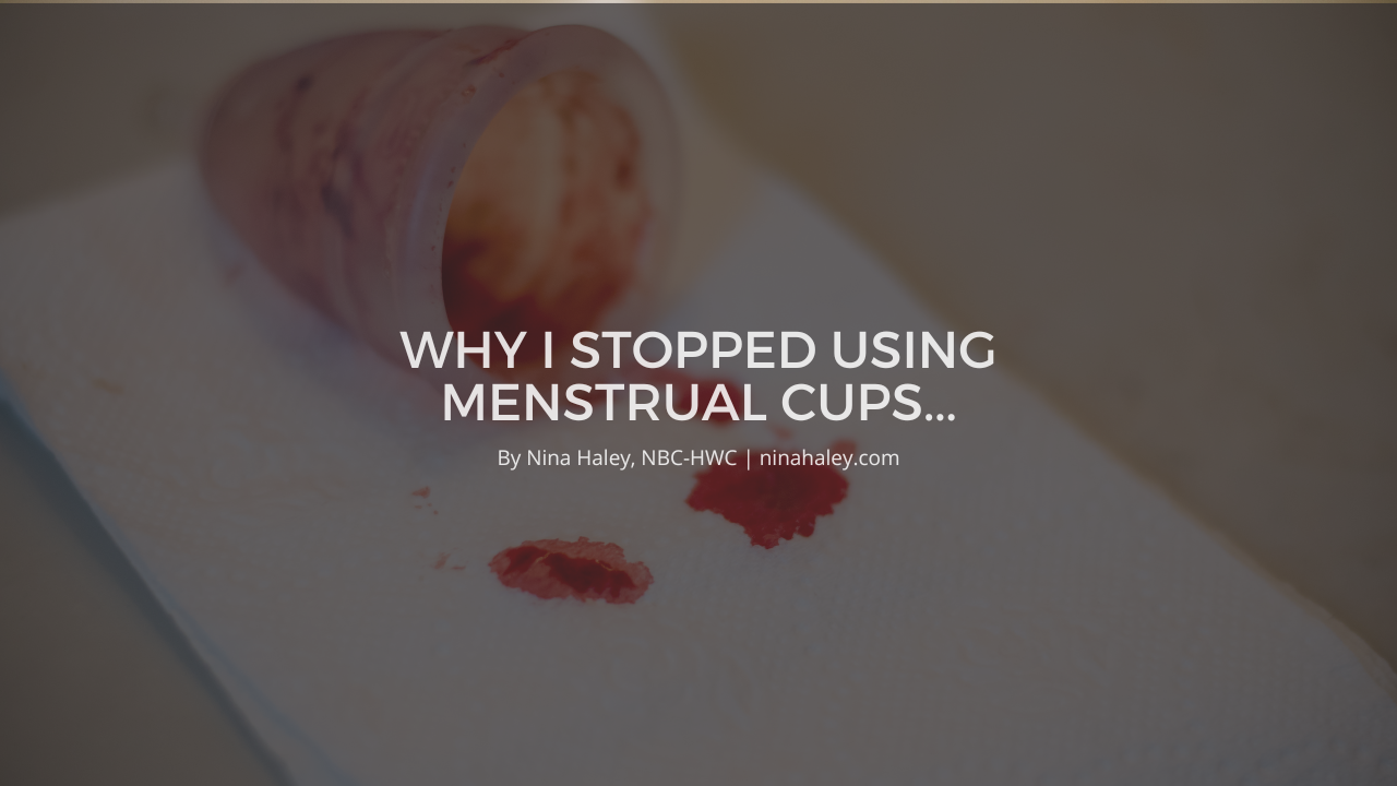 Cloth menstrual pads laid out on a bathroom counter next to a reusable menstrual cup
